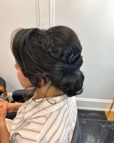 Low updo with a braid on dark hair