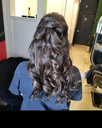 Half up style with full curls on dark hair